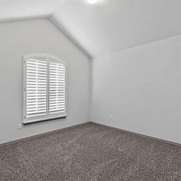 Second of three spacious secondary bedrooms featuring vaulted ceiling, large window allowing in an abundance of natural light, and lush carpet. **This image is from another Saratoga Home with similar floor plan - Myrtle Floorplan.**