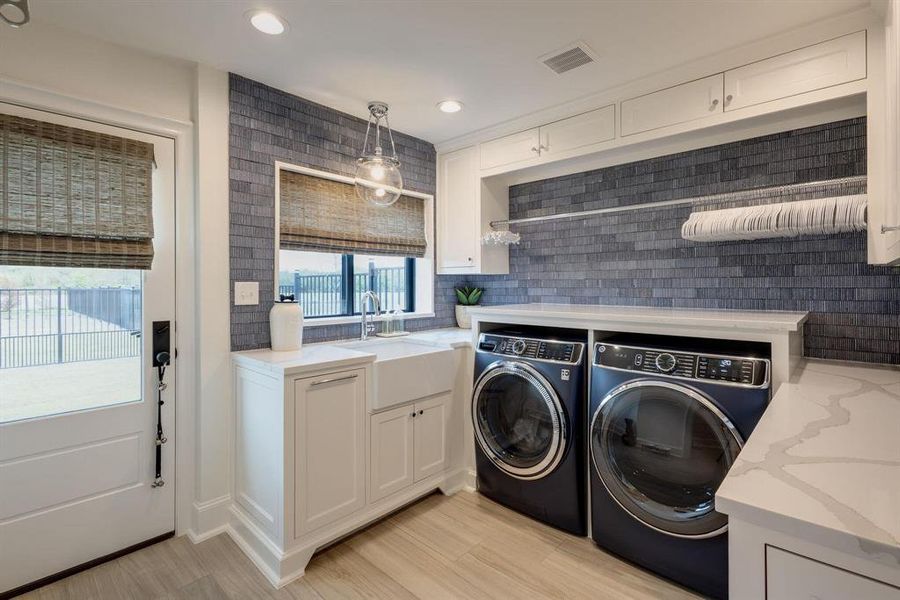 Washroom featuring sink, cabinets, light wood-type flooring, and independent washer and dryer Washroom featuring sink, cabinets, light wood-type flooring, and independent washer and dryer