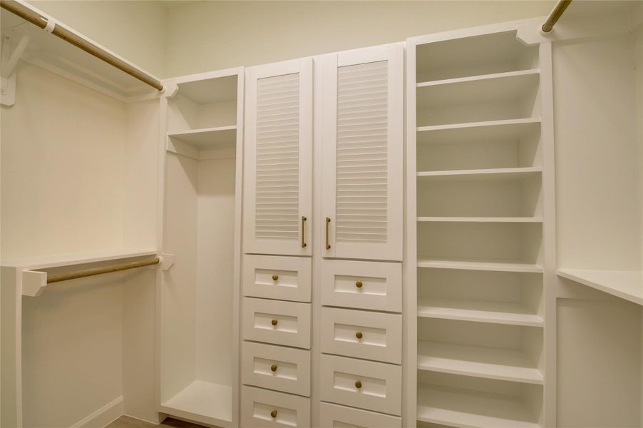 Dream walk-in closet with custom built-ins: doublehanging rods, a wall of open shelves, and a bank ofsoft-close drawers with brass pulls. Center cabinetstores seasonal items out of sight—plenty of spacefor shoes, bags, and everyday organization. Dream walk-in closet with custom built-ins: doublehanging rods, a wall of open shelves, and a bank ofsoft-close drawers with brass pulls. Center cabinetstores seasonal items out of sight—plenty of spacefor shoes, bags, and everyday organization.