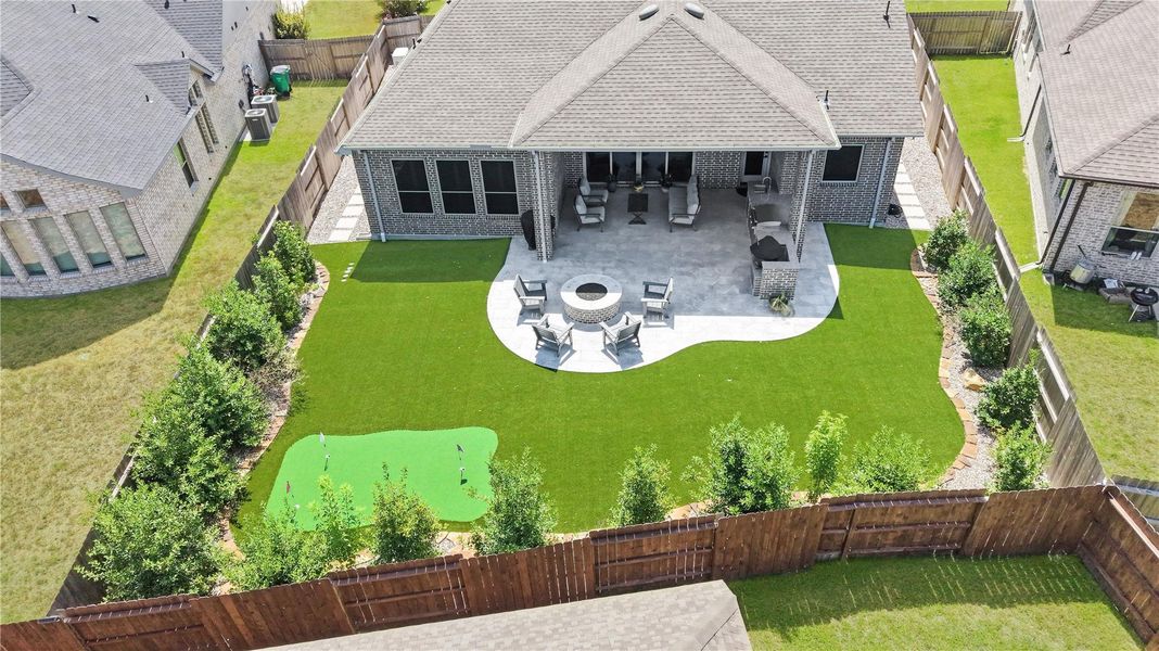 Beautifully landscaped backyard featuring new artificial turf, fresh landscaping, and attractive greenery, creating a clean, low-maintenance, and inviting outdoor space perfect for relaxing and entertaining