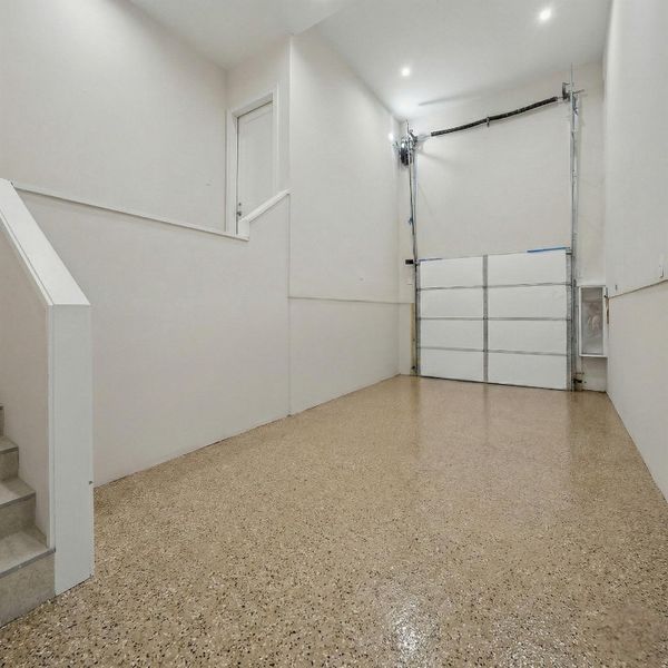 An extended garage bay offering additional depth for oversized vehicles, storage, or a workshop setup. Finished with durable epoxy flooring, high ceilings, and bright recessed lighting, this space is designed for versatility and everyday convenience. Interior access and clean finished walls complete the home’s thoughtfully designed garage layout.