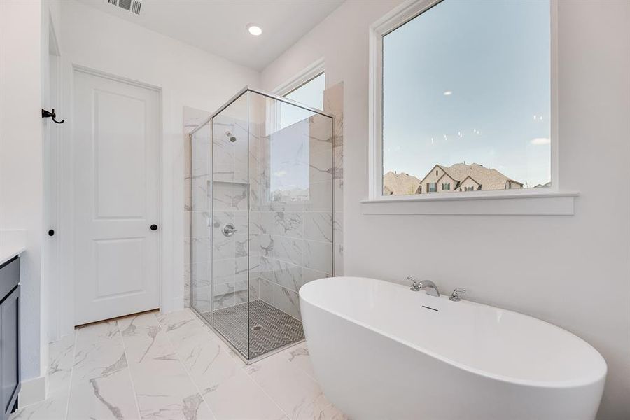Full bathroom featuring a marble finish shower, a freestanding bath, vanity, light marble finish floors, and recessed lighting Full bathroom featuring a marble finish shower, a freestanding bath, vanity, light marble finish floors, and recessed lighting