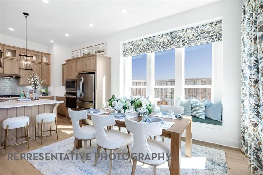 Dining area with light wood-style floors and recessed lighting