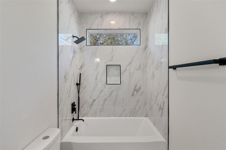 Bathroom featuring toilet and tiled shower / bath