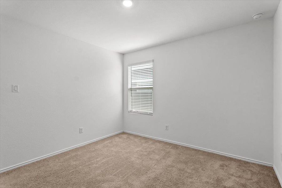 A well-lit bedroom provides a cozy retreat with soft carpeting and natural illumination through a single window. A well-lit bedroom provides a cozy retreat with soft carpeting and natural illumination through a single window.