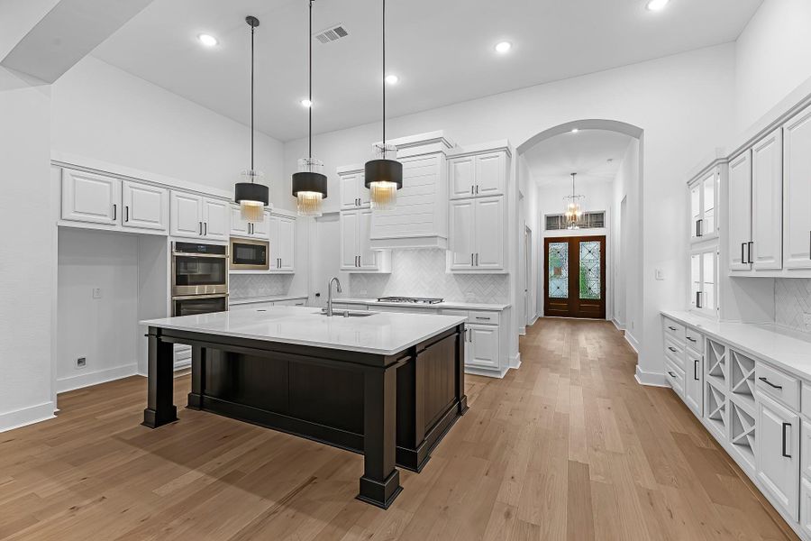 Dramatic entry! View of the double doors, hall, and kitchen from the family room. Dramatic entry! View of the double doors, hall, and kitchen from the family room.