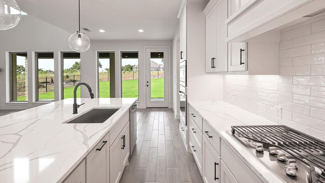 Kitchen with a sink, appliances with stainless steel finishes, tasteful backsplash, white cabinetry, and recessed lighting