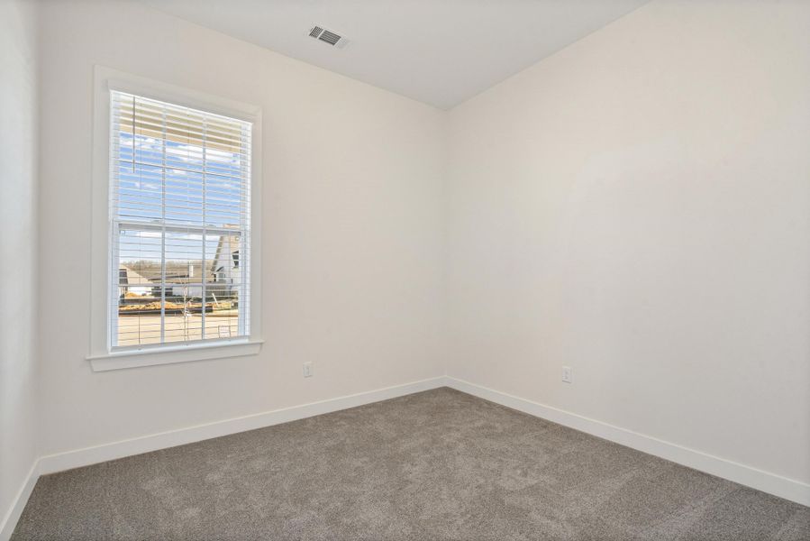 Carpeted empty room with baseboards