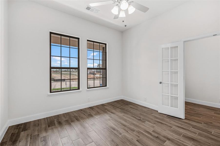 Empty room with wood finished floors and ceiling fan Empty room with wood finished floors and ceiling fan