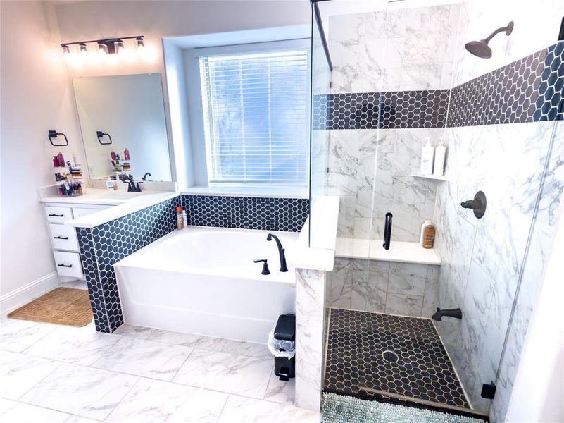 Full bath featuring a marble finish shower, a garden tub, vanity, light marble finish flooring, and pet washing station