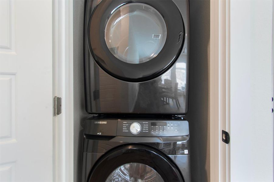 Laundry area with stacked washer and clothes dryer