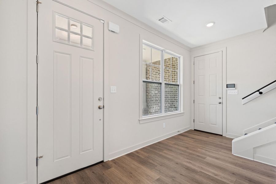 Foyer featuring dark wood-type flooring and stairway