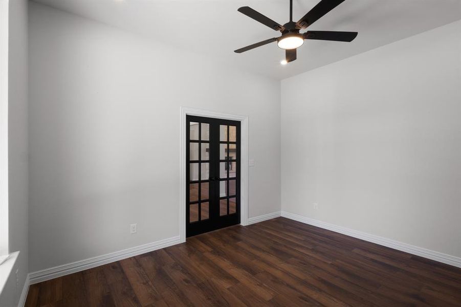 Spare room with french doors, baseboards, a ceiling fan, and dark wood finished floors