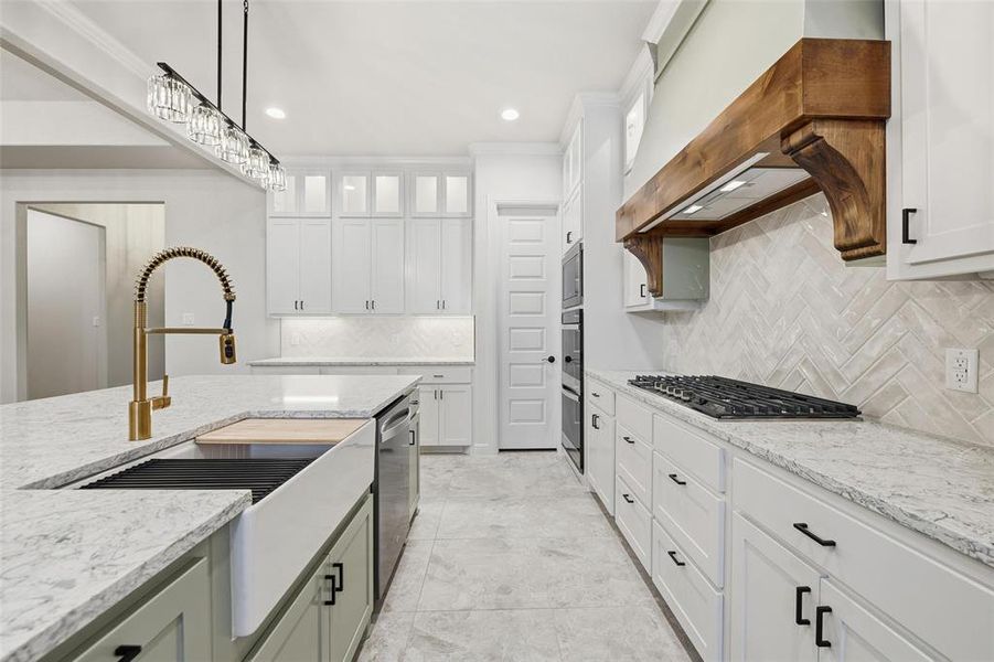 Kitchen with white cabinetry, pendant lighting, light stone counters, backsplash, and glass insert cabinets Kitchen with white cabinetry, pendant lighting, light stone counters, backsplash, and glass insert cabinets