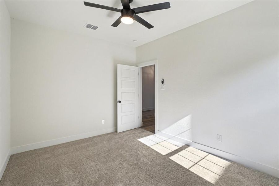 Carpeted spare room with baseboards and a ceiling fan Carpeted spare room with baseboards and a ceiling fan