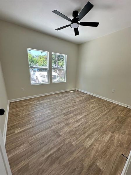 Empty room featuring light wood-style flooring and a ceiling fan