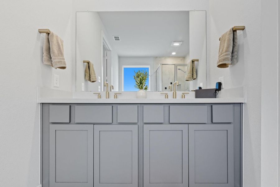The primary bath features dual vanities.
