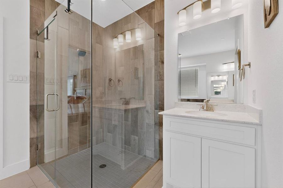 Glass-enclosed shower with wood-finish tile surround and a tiled floor Glass-enclosed shower with wood-finish tile surround and a tiled floor