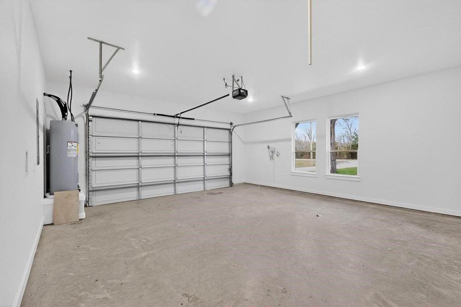 Garage featuring water heater and a garage door opener Garage featuring water heater and a garage door opener