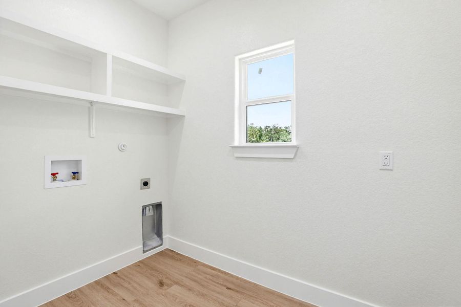Ample shelving provides convenient storage in this well-appointed laundry space.