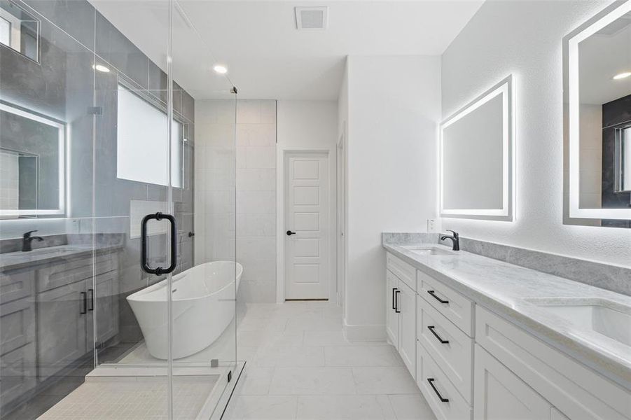 Bathroom with double vanity, a freestanding tub, and a stall shower