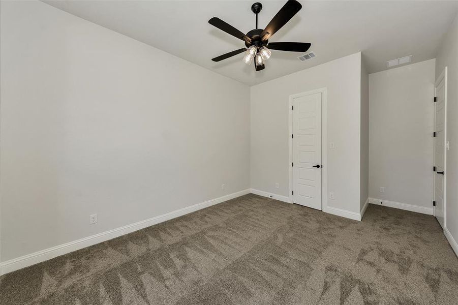 Empty room with carpet floors and ceiling fan
