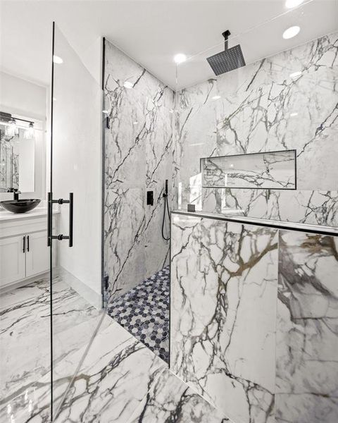 Full bathroom featuring a marble finish shower, vanity, recessed lighting, and light marble finish floors Full bathroom featuring a marble finish shower, vanity, recessed lighting, and light marble finish floors