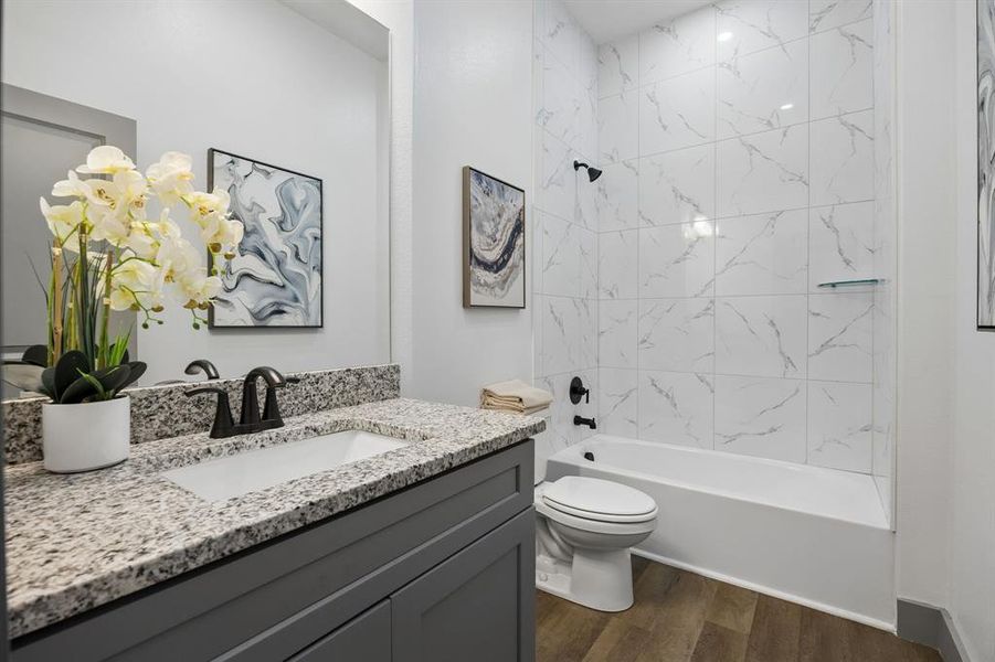 Full bathroom at the front of the home with a vanity and tub-shower combo.