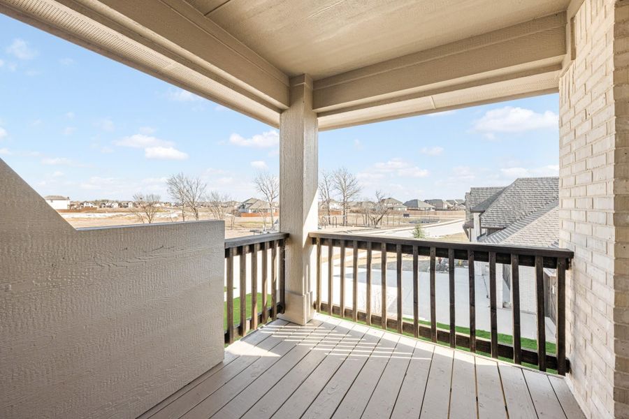 Covered second-floor balcony with dark wood railing and neighborhood views