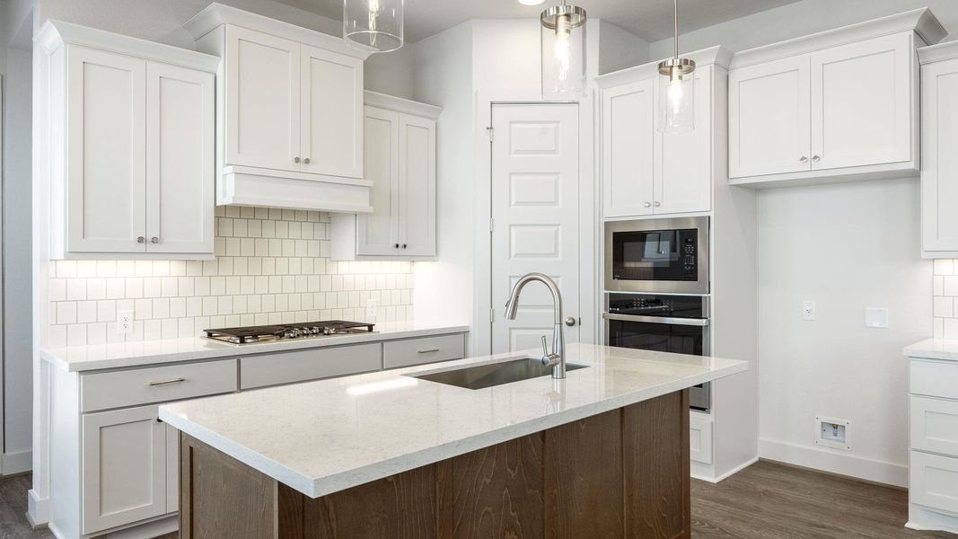 Kitchen featuring tasteful backsplash, white cabinets, and light stone counters Kitchen featuring tasteful backsplash, white cabinets, and light stone counters