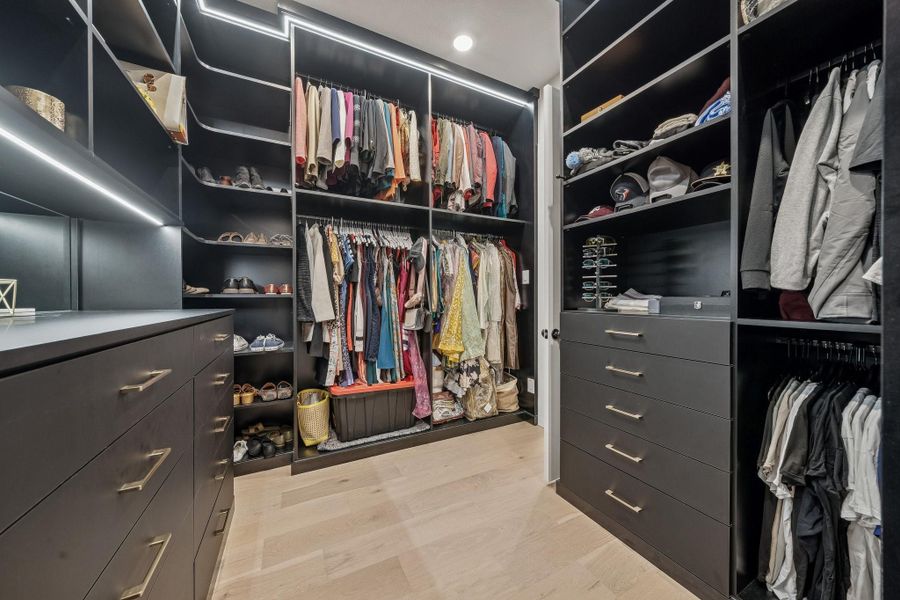The primary closet with custom cabinetry and lighting.