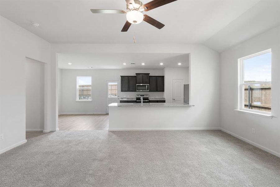 Unfurnished living room featuring light carpet, a ceiling fan, and recessed lighting Unfurnished living room featuring light carpet, a ceiling fan, and recessed lighting