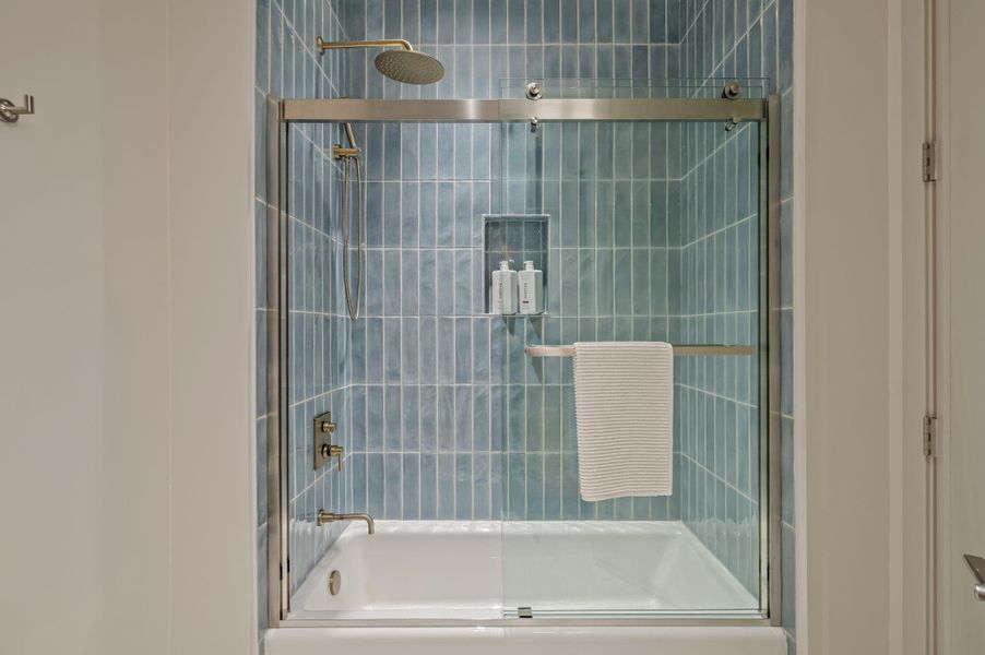 Step into a serene bathroom featuring a tub and shower combo with elegant tile work.