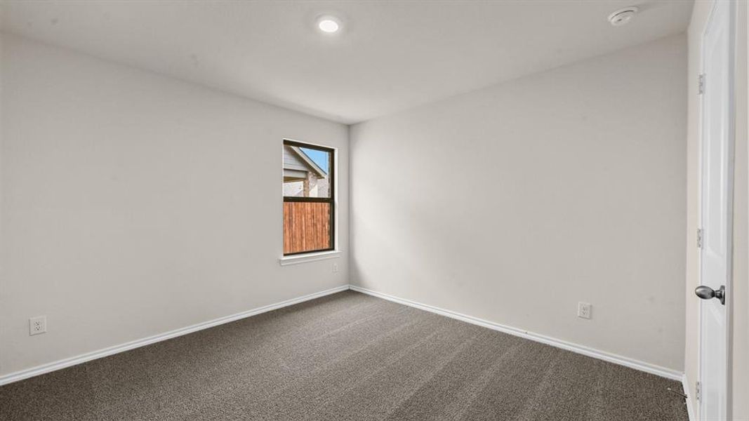 Neutral-toned room featuring a single window with a white frame, recessed ceiling lighting, textured gray carpet, and white baseboards Neutral-toned room featuring a single window with a white frame, recessed ceiling lighting, textured gray carpet, and white baseboards