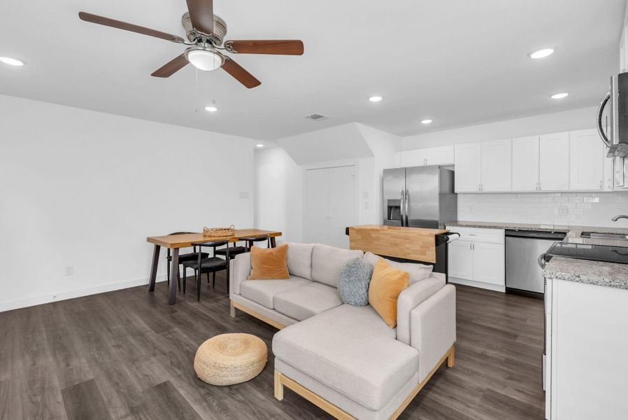 The room includes an open concept living space with stylish LVP flooring complemented by recessed lighting and a ceiling fan. The room includes an open concept living space with stylish LVP flooring complemented by recessed lighting and a ceiling fan.
