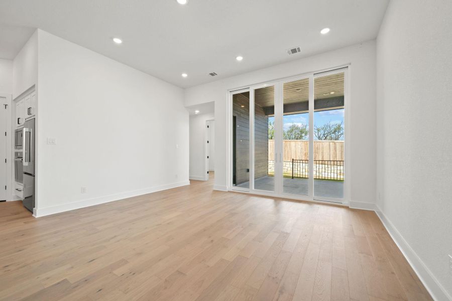 Empty room with light wood-type flooring and recessed lighting