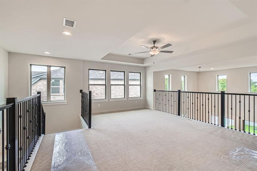 Hall featuring an upstairs landing, carpet floors, plenty of natural light, a tray ceiling, and recessed lighting Hall featuring an upstairs landing, carpet floors, plenty of natural light, a tray ceiling, and recessed lighting