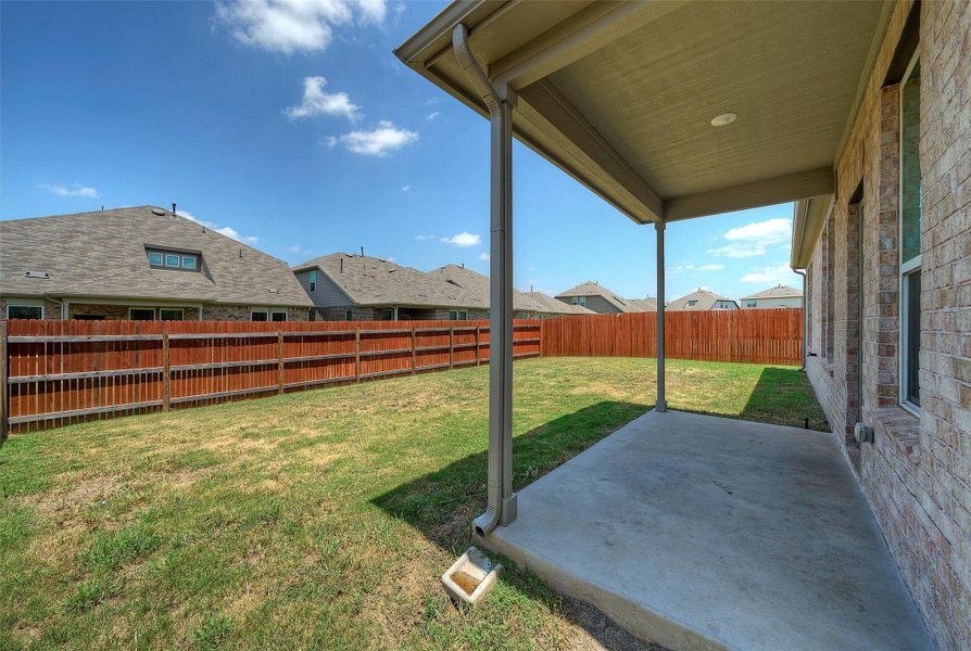 A spacious backyard enclosed by a wooden fence provides a private outdoor retreat. A spacious backyard enclosed by a wooden fence provides a private outdoor retreat.