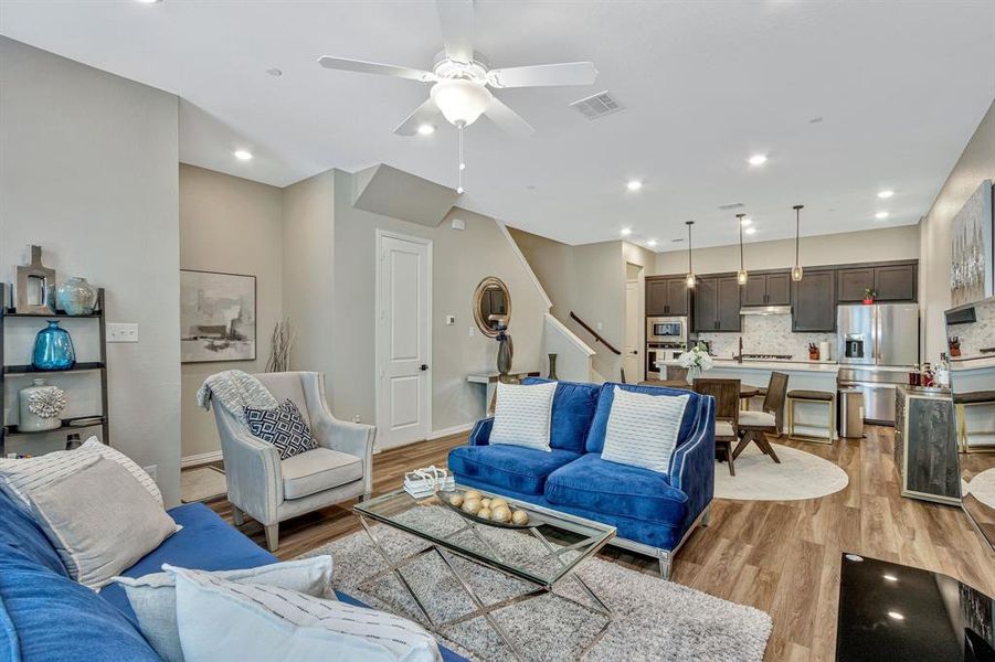 Living room featuring ceiling fan and light hardwood / wood-style flooring