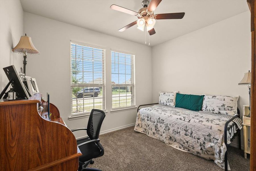 Bedroom featuring carpet floors, a desk, and a ceiling fan Bedroom featuring carpet floors, a desk, and a ceiling fan