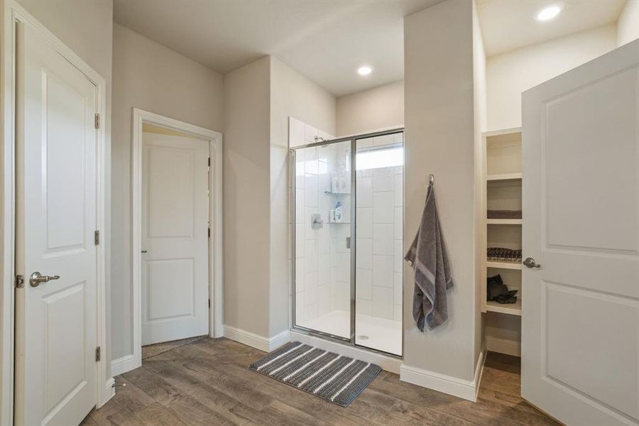 Full bath featuring a stall shower and dark wood-style floors Full bath featuring a stall shower and dark wood-style floors