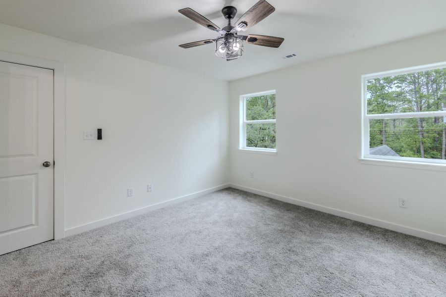 Well-lit room featuring ample natural light and a stylish ceiling fan. Well-lit room featuring ample natural light and a stylish ceiling fan.