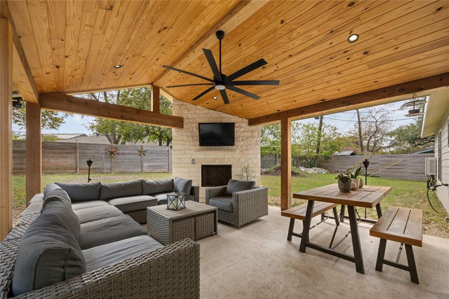 Sunroom / solarium featuring an outdoor fireplace, a patio, ceiling fan, and outdoor lounge area