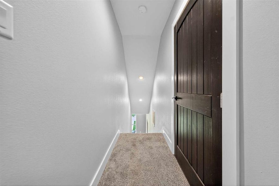 Hallway featuring carpet floors, recessed lighting, and a textured wall Hallway featuring carpet floors, recessed lighting, and a textured wall