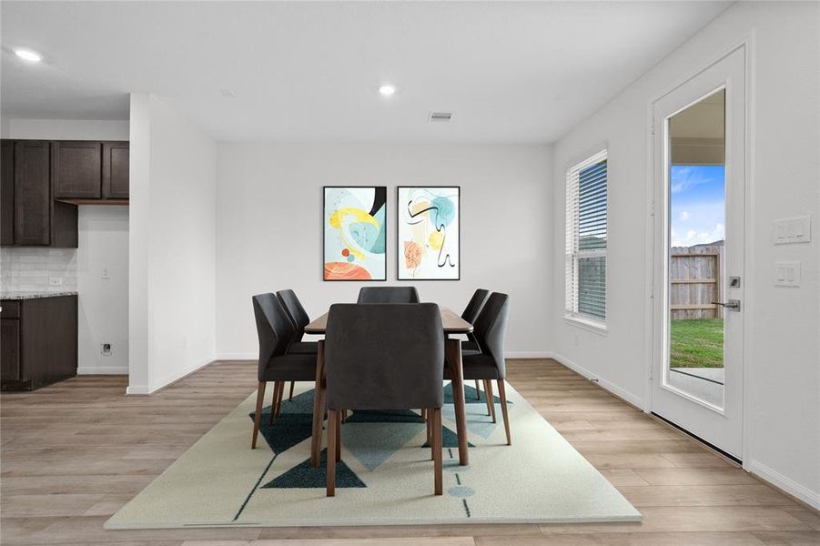 Make memories gathered around the table with your family and friends! This dining room features high ceilings, large window with privacy blinds, gorgeous vinyl plank flooring, and recessed lighting