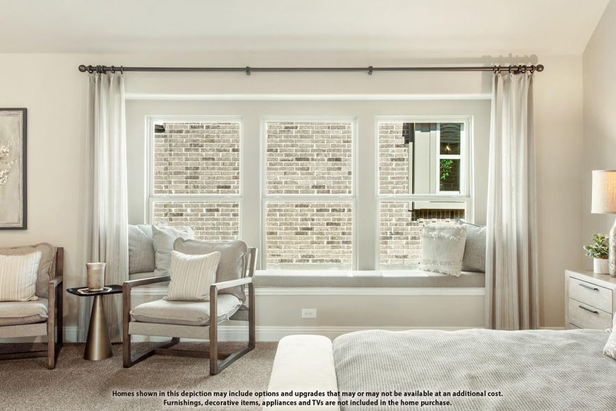 Bedroom sitting area with built-in window seat, accent chair, and triple windows with sheer curtains