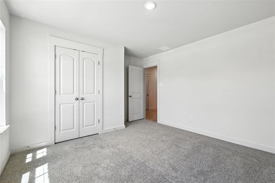 Unfurnished bedroom featuring carpet floors and a closet Unfurnished bedroom featuring carpet floors and a closet