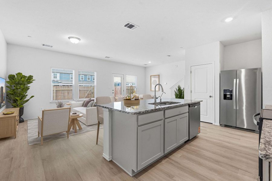 Central kitchen island with a double basin sink, gooseneck faucet, and granite-style countertop Central kitchen island with a double basin sink, gooseneck faucet, and granite-style countertop