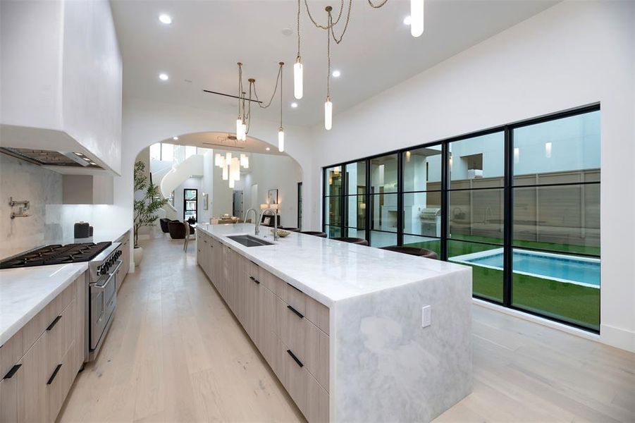 Kitchen featuring a large island with sink, light wood-style floors, modern cabinets, and recessed lighting