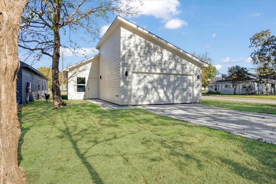 Back of property featuring a lawn and a garage